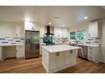 Bright kitchen features white cabinetry, stainless steel appliances and a center island with quartz countertops at 1342 Carter Rd, Decatur, GA 30030