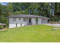 Charming single-story home with updated exterior, well-manicured lawn and an attached garage at 2636 Flagstone Se Dr, Atlanta, GA 30316