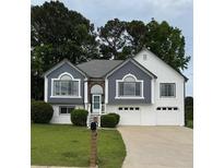 Inviting home featuring a two-car garage, manicured lawn, and charming architectural details at 4735 Julian Way, Acworth, GA 30101