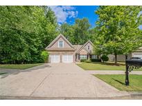 Charming two-story home featuring a well-maintained lawn and a convenient two-car garage at 2557 Woodford Ln, Buford, GA 30519