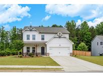 Charming two-story home with white siding, a well-manicured lawn, and an attached two-car garage at 165 Brookstone E Park, Acworth, GA 30101