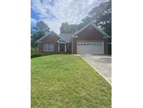 Charming brick home with a well-maintained lawn and attached two-car garage, perfect for suburban living at 1669 Azalea Dr, Lawrenceville, GA 30043