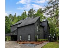 Modern two-story home with dark siding, well-manicured landscaping and multiple decks at 270 Shady Marsh Trl, Roswell, GA 30075