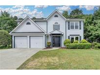 Charming two-story home with a well-manicured lawn, two-car garage, and inviting entrance at 3668 Burel Mill Dr, Buford, GA 30519
