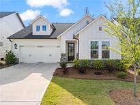 Charming two-story home with a well-manicured front yard and a two-car garage at 5121 Aster Bnd, Canton, GA 30114