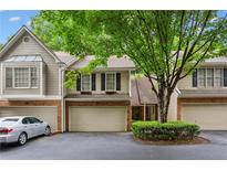 Charming townhome featuring a brick facade, attached garage, and lush landscaping at 2908 Woodruff Se Dr, Smyrna, GA 30080