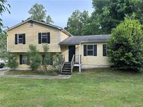 Charming home with a classic yellow exterior, surrounded by lush greenery and a well-maintained front yard at 2940 Caller Ct, Marietta, GA 30060