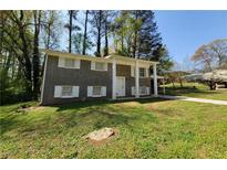 Traditional two-story home with a gray brick facade, white trim, and a spacious front yard at 3796 Leesburg Sw Ct, Atlanta, GA 30331