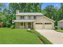 Charming two-story home featuring an attached two-car garage, well-manicured lawn and mature trees at 1284 Brandl Dr., Marietta, GA 30008