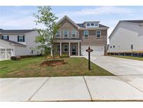 Charming two-story brick home boasts a well-manicured lawn and attached two car garage at 1640 Tide Mill Rd, Cumming, GA 30040