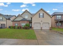 Charming two-story home featuring a well-maintained lawn, a two-car garage, and a brick and siding exterior at 4581 Sagebrush Ct, Snellville, GA 30039