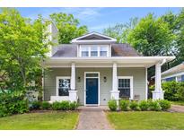 Charming home with a covered front porch, lush landscaping, and a blue front door at 212 Haralson Ne Ave, Atlanta, GA 30307