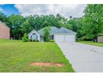 Charming single-story home with a well-maintained front lawn and a two-car garage at 297 Edison Dr, Stockbridge, GA 30281