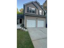 Two-story home featuring a two-car garage, neutral siding and black shuttered windows at 3534 Oakshire Se Way, Atlanta, GA 30354