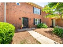 Charming brick townhome featuring a welcoming front entrance with well-maintained landscaping and walkway at 3677 Blackshear Ct, Duluth, GA 30096