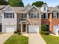Charming brick townhome with an attached garage, manicured lawn, and welcoming front entrance at 3626 Lantern Crest Cv, Scottdale, GA 30079