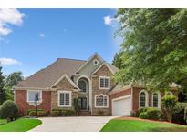 Charming two-story home with brick and stone exterior, well-manicured lawn, and mature trees at 1029 Ector Nw Dr, Kennesaw, GA 30152
