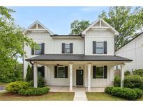 Charming two-story home with white siding, black shutters, and a welcoming front porch at 3123 Cedar St, Scottdale, GA 30079
