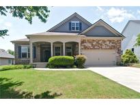 Charming single-Gathering home featuring a well-manicured lawn, stone accents, and a welcoming front porch at 514 Creekshire Cir, Canton, GA 30115