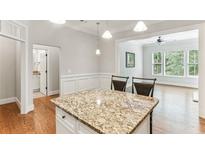 Bright eat-in kitchen with granite island, hardwood floors, and views into the open living area at 11 Perimeter E Ctr # 1402, Dunwoody, GA 30346