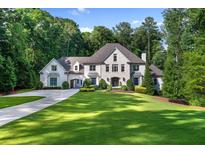 Stunning home featuring lush landscaping, manicured lawn, and elegant architectural details, with a long drive leading up to the property at 1191 W Conway Dr, Atlanta, GA 30327