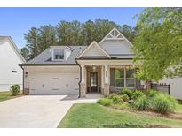 Charming single-Gathering home showcasing brick and siding facade, a well-manicured lawn, and a welcoming front porch at 419 Southland Cir, Canton, GA 30115