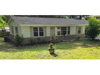 Charming single-story home with light-colored exterior, dark roof, and well-maintained front lawn at 50 Woodland St, Buford, GA 30518