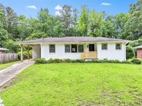 Charming white brick home featuring a well-manicured lawn, covered carport, and a cozy, inviting facade at 120 Ingleside Dr, Jonesboro, GA 30236