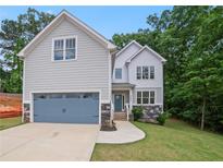 Charming two-story home with gray siding, stone accents, blue garage door, and a well-manicured front lawn at 2463 Whites Rdg, Decatur, GA 30034