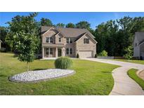 Beautiful two-story brick home with a well-manicured lawn, two-car garage, and inviting curb appeal at 953 Mystic Way, Hampton, GA 30228