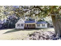 Charming one-story home featuring a covered porch, a well-maintained lawn, and mature shade trees at 2530 Flippen Rd, Stockbridge, GA 30281