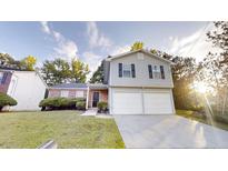 Charming two-story home with a well-maintained lawn and a two-car garage at 765 Stonebridge Run, Lithonia, GA 30058