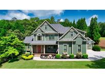 Charming two-story home with landscaped front yard and welcoming entrance, complemented by mature trees and lush greenery at 102 Cavit Ct, Canton, GA 30114