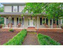 Inviting front porch with classic columns, seating, and a well-manicured walkway leading to the front door at 9060 Par Dr, Douglasville, GA 30134