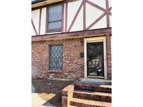Charming townhome featuring brick facade, secure barred windows, and inviting front entrance at 3298 Abbeywood Dr, Decatur, GA 30034