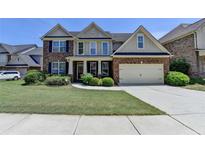 Charming two-story home featuring a brick facade, attached garage, and well-manicured lawn at 25 Kaktovic Ct, Grayson, GA 30017