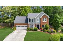 Traditional two-story home with a well-maintained lawn, lush landscaping, and an attached two-car garage at 2865 Ivey Oaks Ln, Roswell, GA 30076