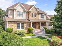 Beautiful home boasts a stone and siding exterior, lush landscaping, and a welcoming front porch at 2810 Promenade Pl, Buford, GA 30519
