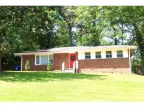 Charming brick home with a bright red front door and manicured lawn at 579 Kenridge Cir, Stone Mountain, GA 30083