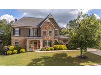 Charming two-story home featuring stone and stucco accents, a well-manicured lawn, and inviting curb appeal at 208 Eagles Flight, Villa Rica, GA 30180