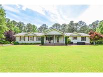 Charming ranch-style home with a manicured front yard and inviting covered porch at 2997 Happy Hollow Se Dr, Conyers, GA 30094