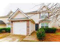 Charming two-story home featuring a stone-accented garage and well-maintained landscaping at 225 Colser Dr, Covington, GA 30016