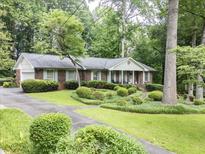 Charming brick home featuring manicured landscaping and a welcoming front yard with mature trees at 3792 Harts Mill Ne Ln, Brookhaven, GA 30319