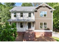 Charming two-story home with a brick foundation, covered porch, and well-manicured landscaping at 5150 Shadow Path Sw Ln, Lilburn, GA 30047