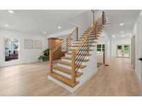 Bright, open staircase featuring wood treads, black metal railings, and plenty of natural light at 5150 Shadow Path Sw Ln, Lilburn, GA 30047
