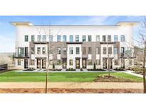 Modern townhome complex boasts a manicured lawn and elegant brick and white facade at 7130 Summit Pl, Alpharetta, GA 30009