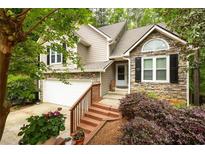 Charming home featuring stone accents, a cozy front porch, and a well-maintained landscaped yard at 3573 Bramwell Nw Xing, Kennesaw, GA 30144