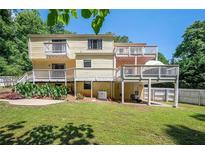 Multi-level home featuring spacious backyard and multiple wooden decks perfect for outdoor relaxation and entertaining at 1202 Laurel Cliff Se Dr, Smyrna, GA 30082