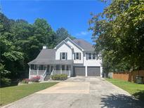 Charming two-story home with a welcoming front porch and a spacious driveway at 402 Hancock Ct, Woodstock, GA 30188
