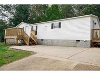 Charming single-story home features white siding, black shutters, and a welcoming wooden porch at 320 White Birch Dr, Covington, GA 30016